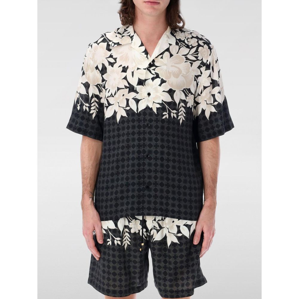 Chemise en soie noire à motif de la marque Amiri, détails élégants et tissu luxueux visibles sur l'image.