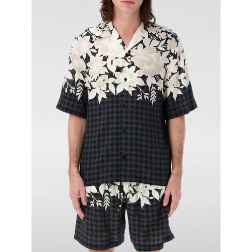 Chemise en soie noire à motif de la marque Amiri, détails élégants et tissu luxueux visibles sur l'image.