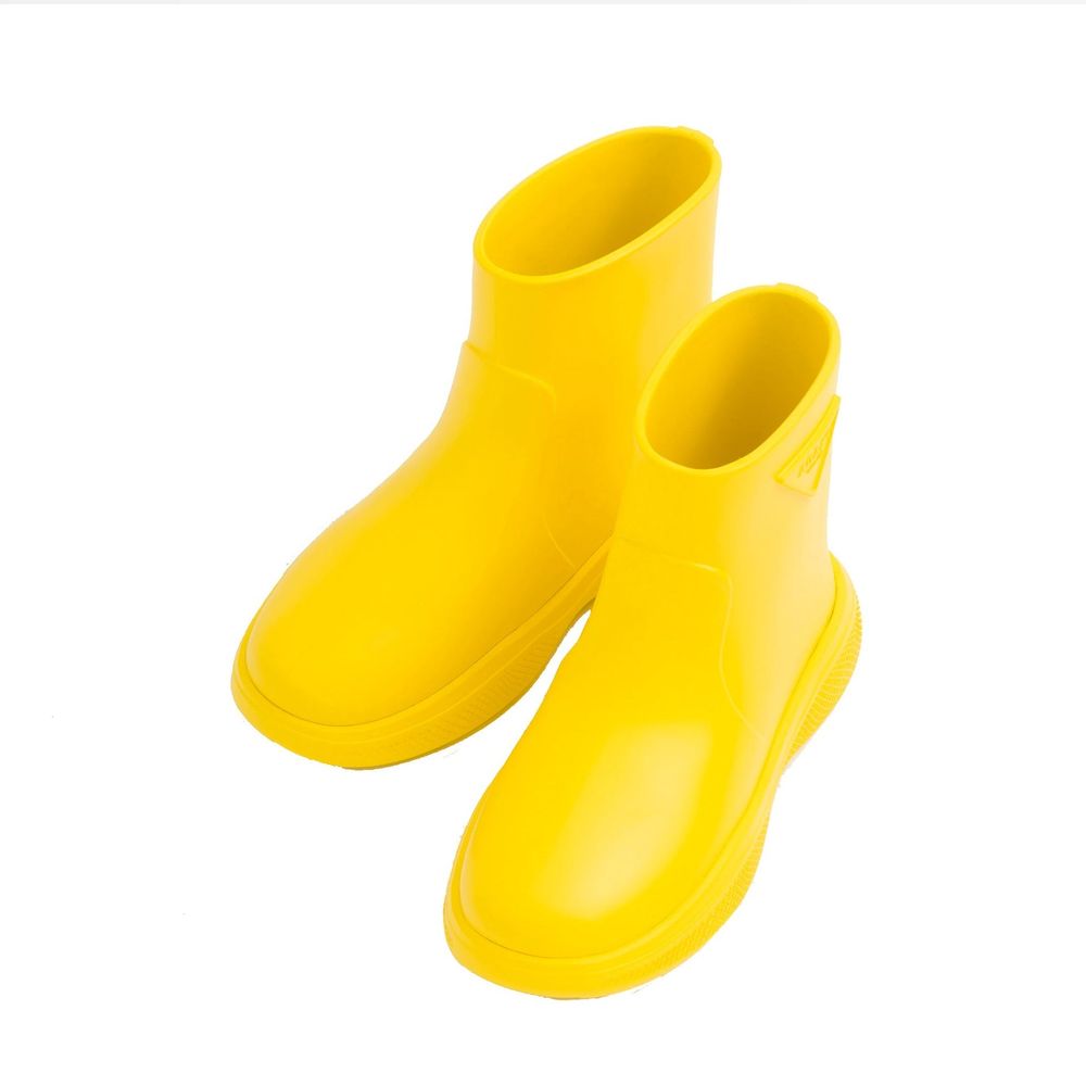 Bottes de pluie en caoutchouc bicolores Prada, style imperméable, avec semelle antidérapante et logo Prada visible.