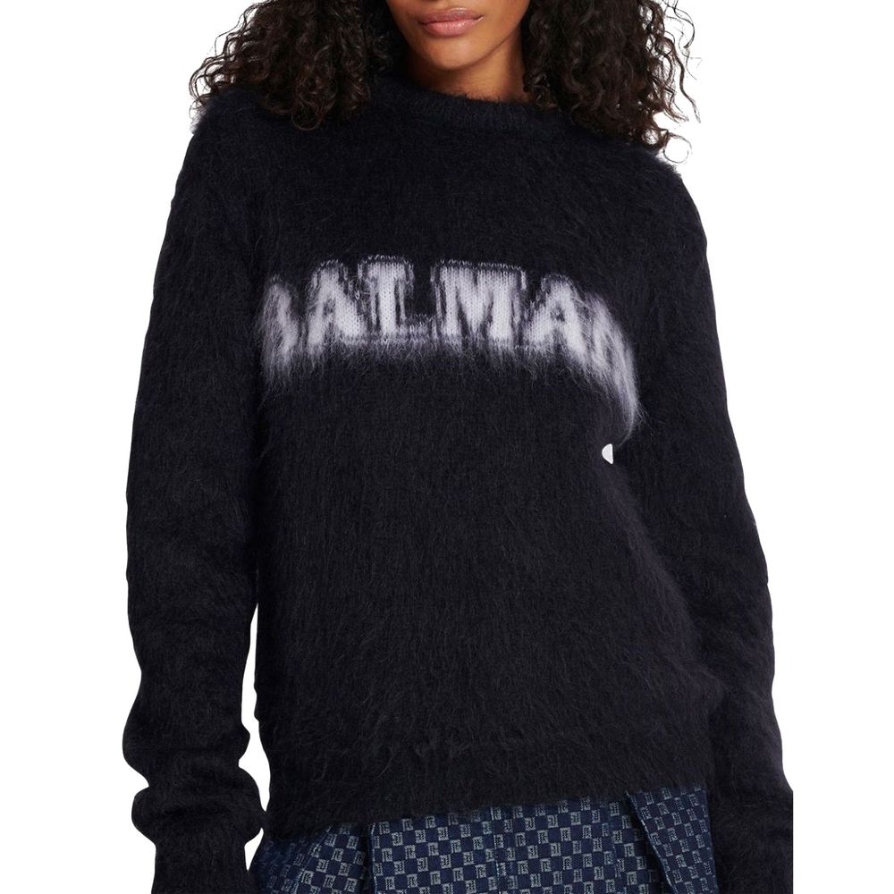 Sweat-shirt noir en mohair de Balmain, à manches longues avec logo brodé, porté sur un mannequin.