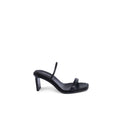 Sandales à talons aiguilles en cuir noir de Calvin Klein, style élégant et moderne, visibles avec brides fines et talon haut.
