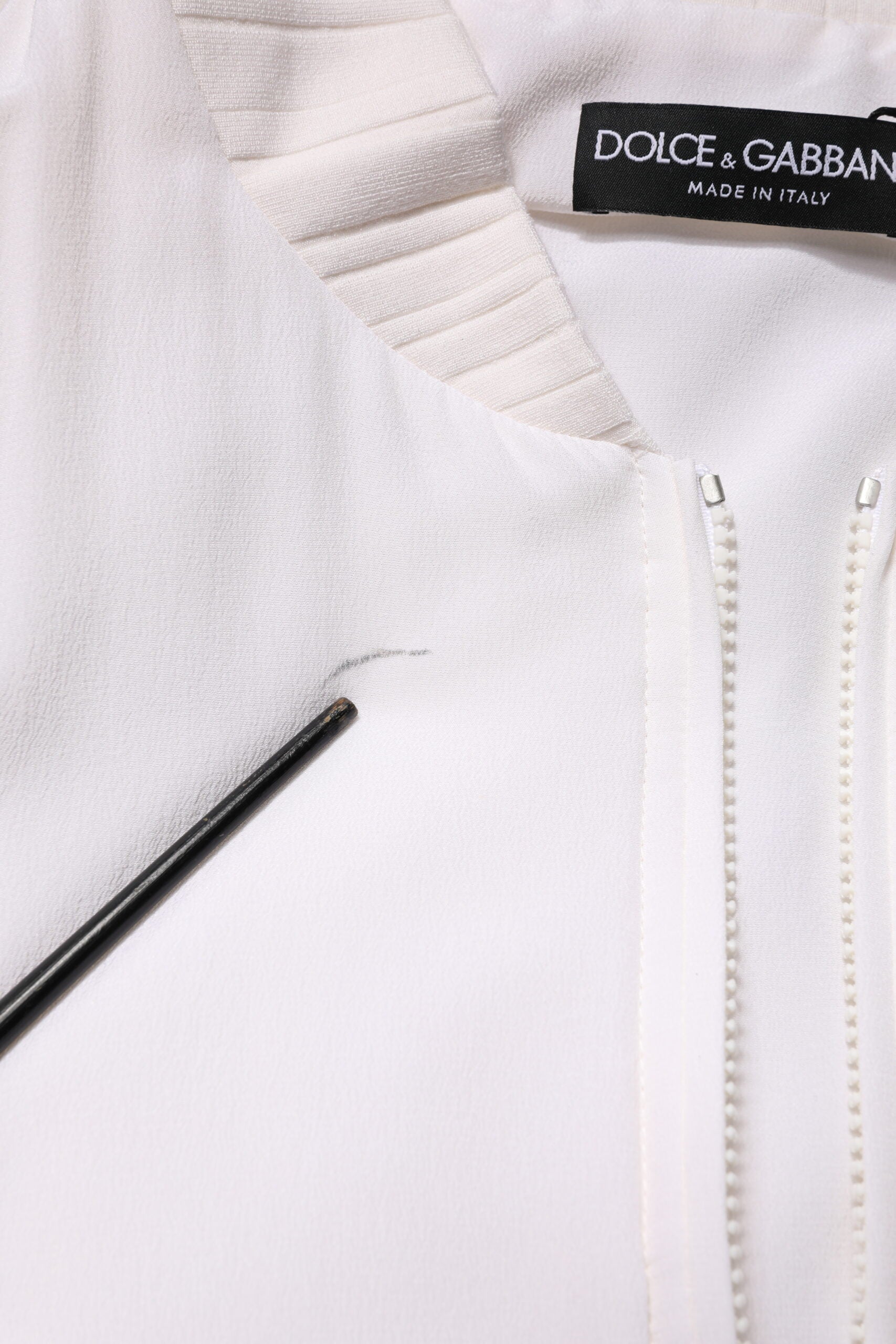Blouson bomber en soie blanche Dolce & Gabbana avec fermeture éclair complète, style élégant et tissu doux visible sur l'image.