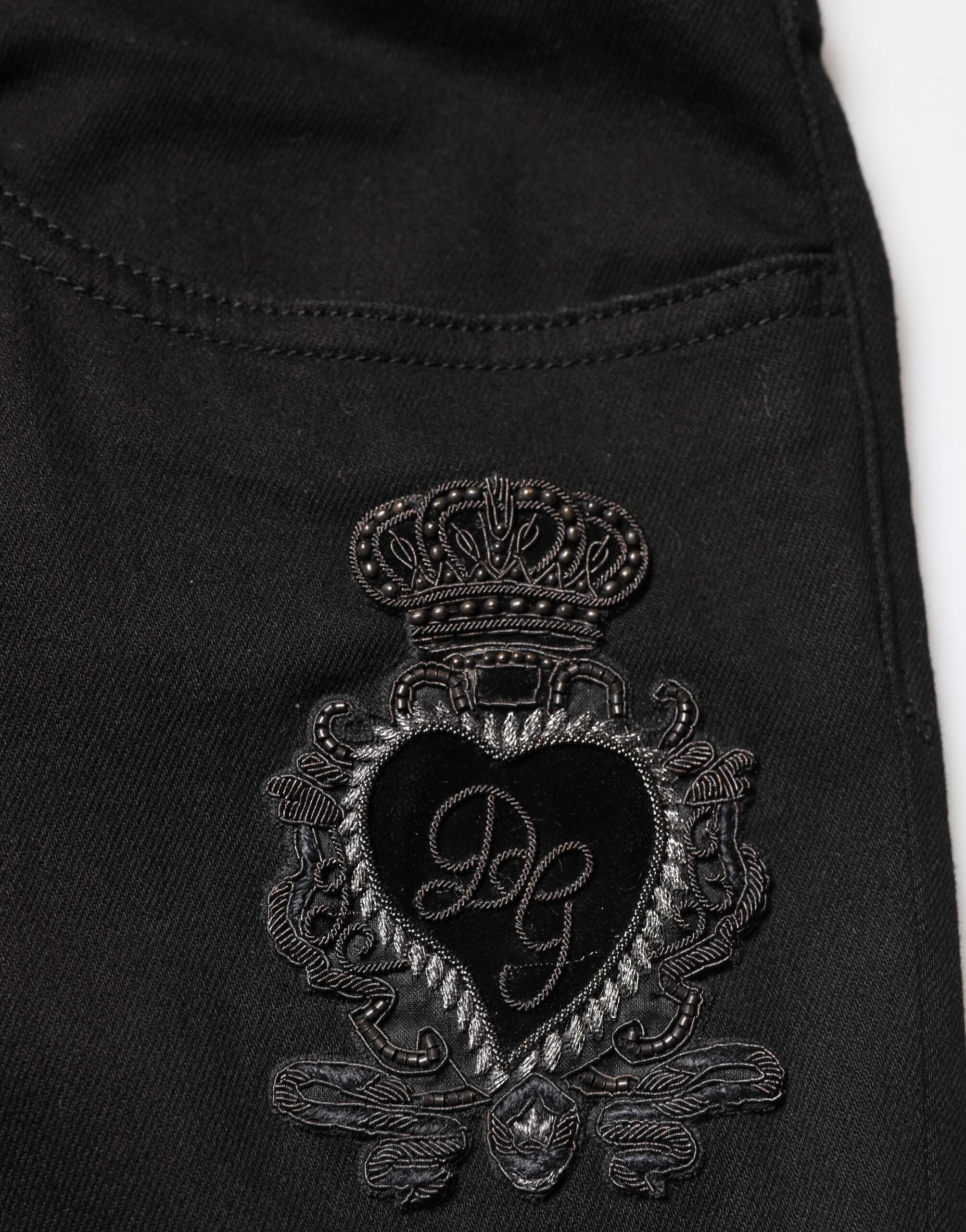 Jeans slim en denim noir Dolce & Gabbana Sacred Heart pour homme, avec détails de cœur sacré sur le côté.