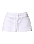 Jupe courte en coton mélangé blanc de Dolce & Gabbana, coupe mi-haute et style évasé, portée avec détails visibles.