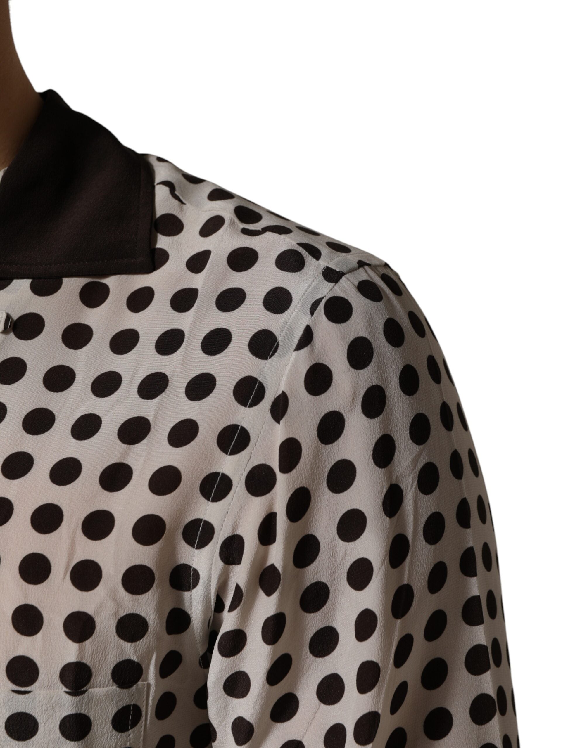 Chemise homme en soie Dolce & Gabbana blanche et noire à pois, style décontracté, avec col et boutons visibles.