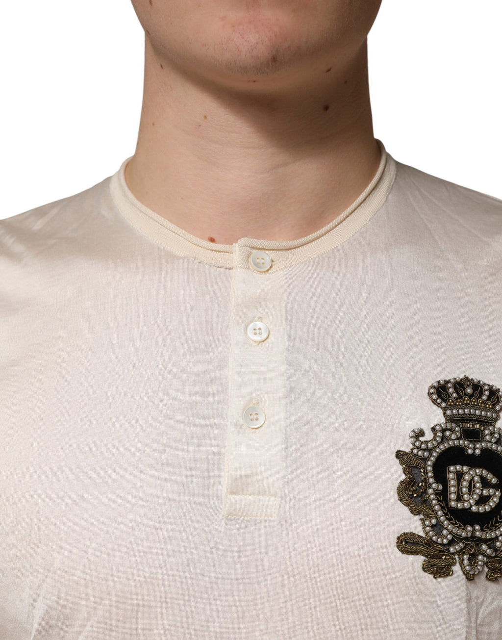 T-shirt pour homme Dolce & Gabbana en soie blanche avec logo patch, style henley, coupe élégante et détails modernes.