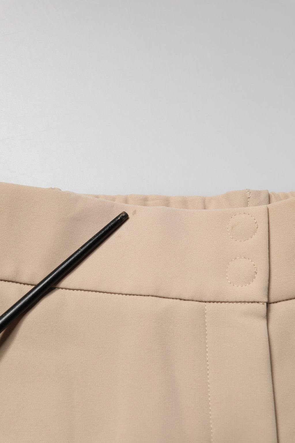 Pantalon chino beige à taille haute et coupe droite de la marque Emporio Armani, visible en détail dans l'image.