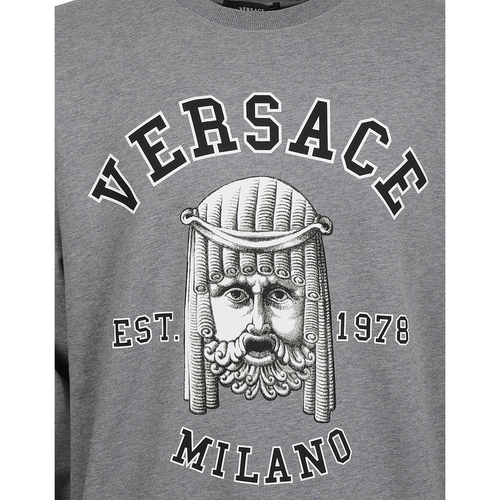 Sweatshirt gris en coton de la marque Versace, affichant un design élégant avec logo visible sur le devant.