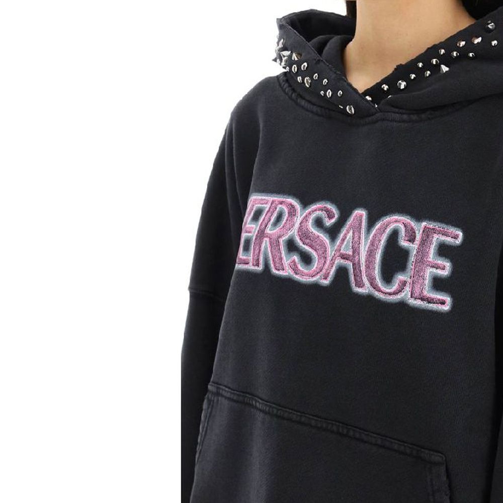 Sweat-shirt en coton noir de la marque Versace, avec logo emblématique visible sur le devant.