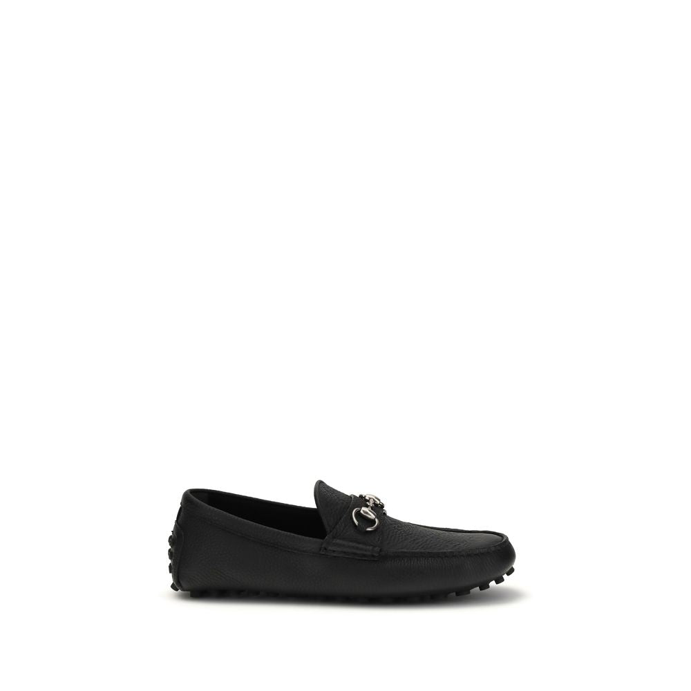 Mocassins Gucci en cuir de veau noir Bos Taurus, chaussure slip-on élégante pour homme, en gros plan sur la paire.