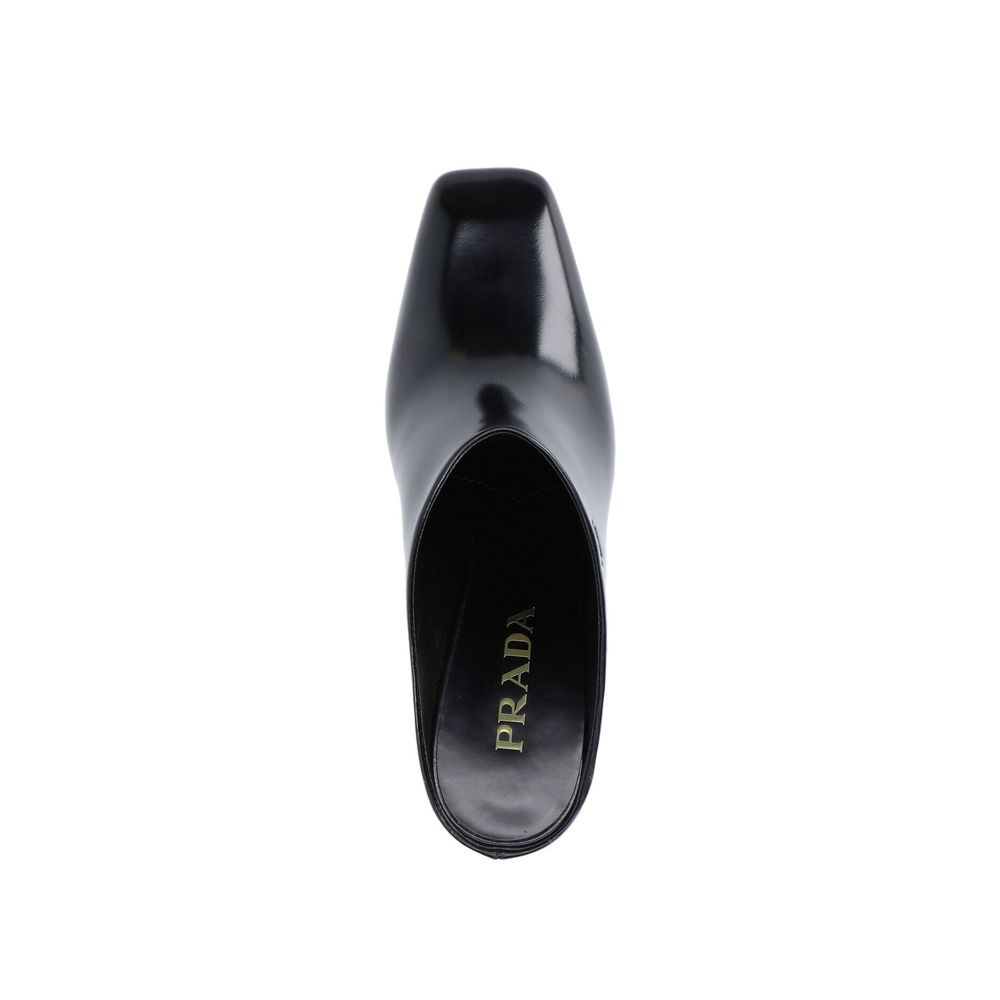 Mules en cuir de veau noir Prada, style élégant et moderne, avec semelle plateforme et design épuré.