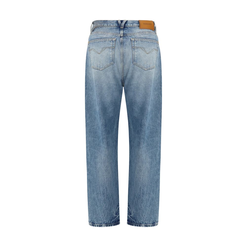 Jeans en denim en coton bleu de la marque Versace, coupe classique et détails de luxe visibles sur le pantalon.