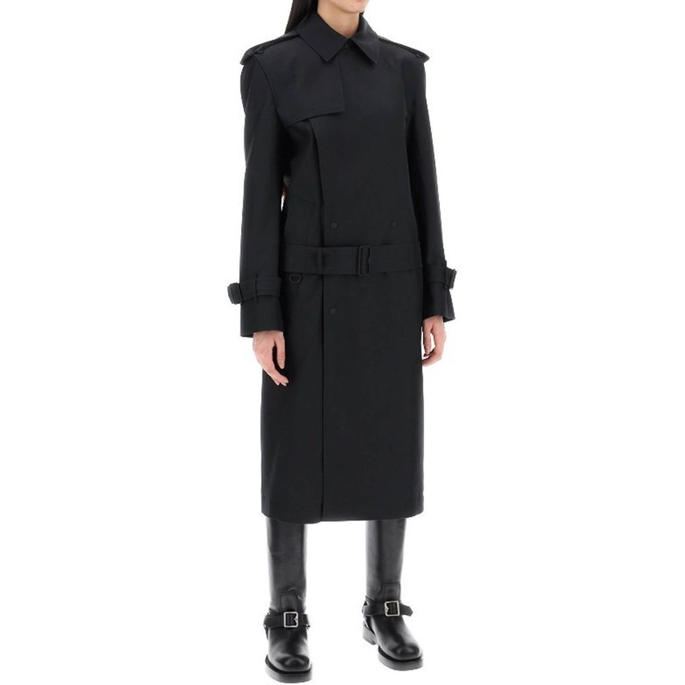 Manteau en polyester noir Burberry, coupe élégante, avec détails classiques, porté en extérieur.