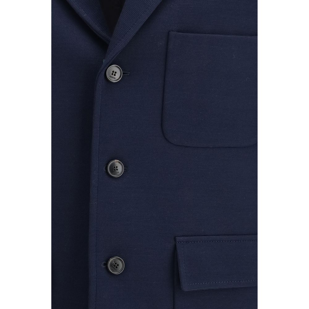 Veste longue en coton bleu Gucci, mode élégante, visible détail de la fermeture et des poches, sur fond neutre.