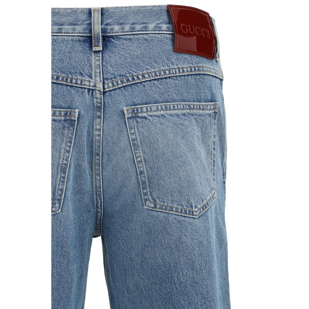 Jeans slim en coton bleu Gucci, coupe ajustée, détails modernes et logo Gucci visible.