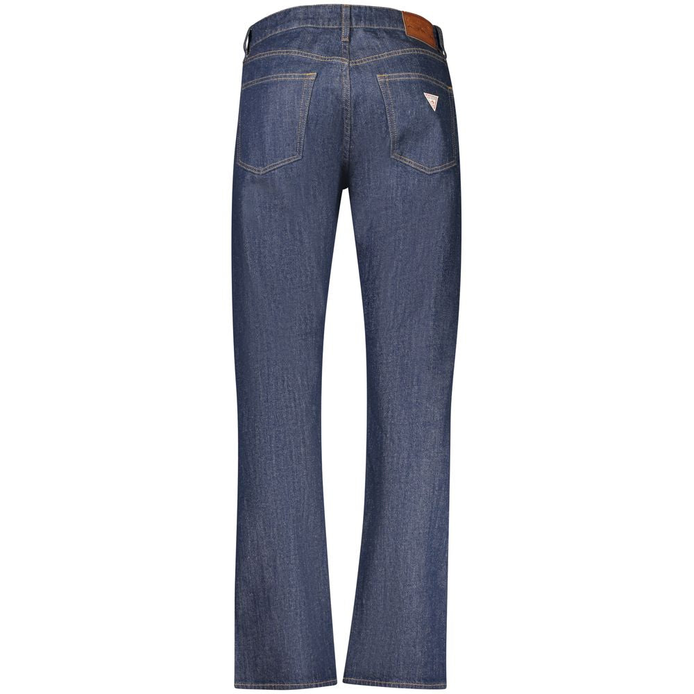 Jean homme Guess Jeans en coton bleu, coupe classique, visible avec fermeture éclair et poches avant sur fond neutre.