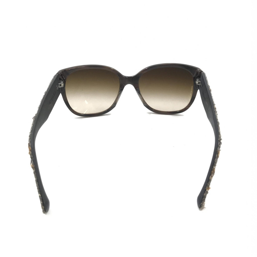Lunettes de soleil Chanel avec monture marron et accents en tweed, design élégant et sophistiqué, vue de face.