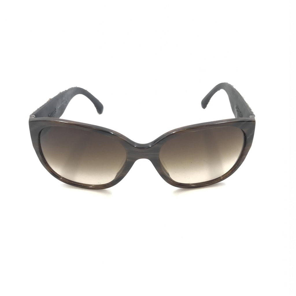 Lunettes de soleil Chanel avec monture marron et accents en tweed, style élégant et sophistiqué, vue de face.