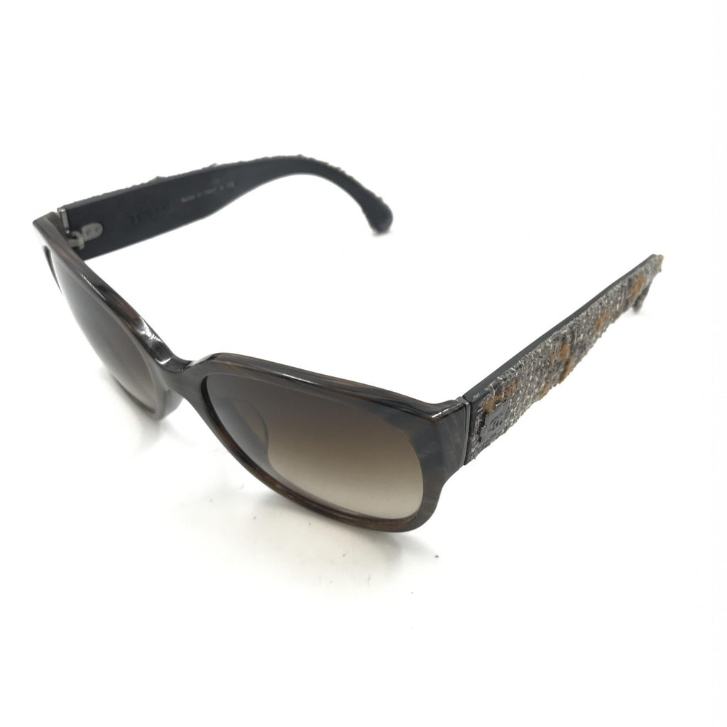 Lunettes de soleil Chanel à monture brune avec accents en tweed, style élégant et sophistiqué.