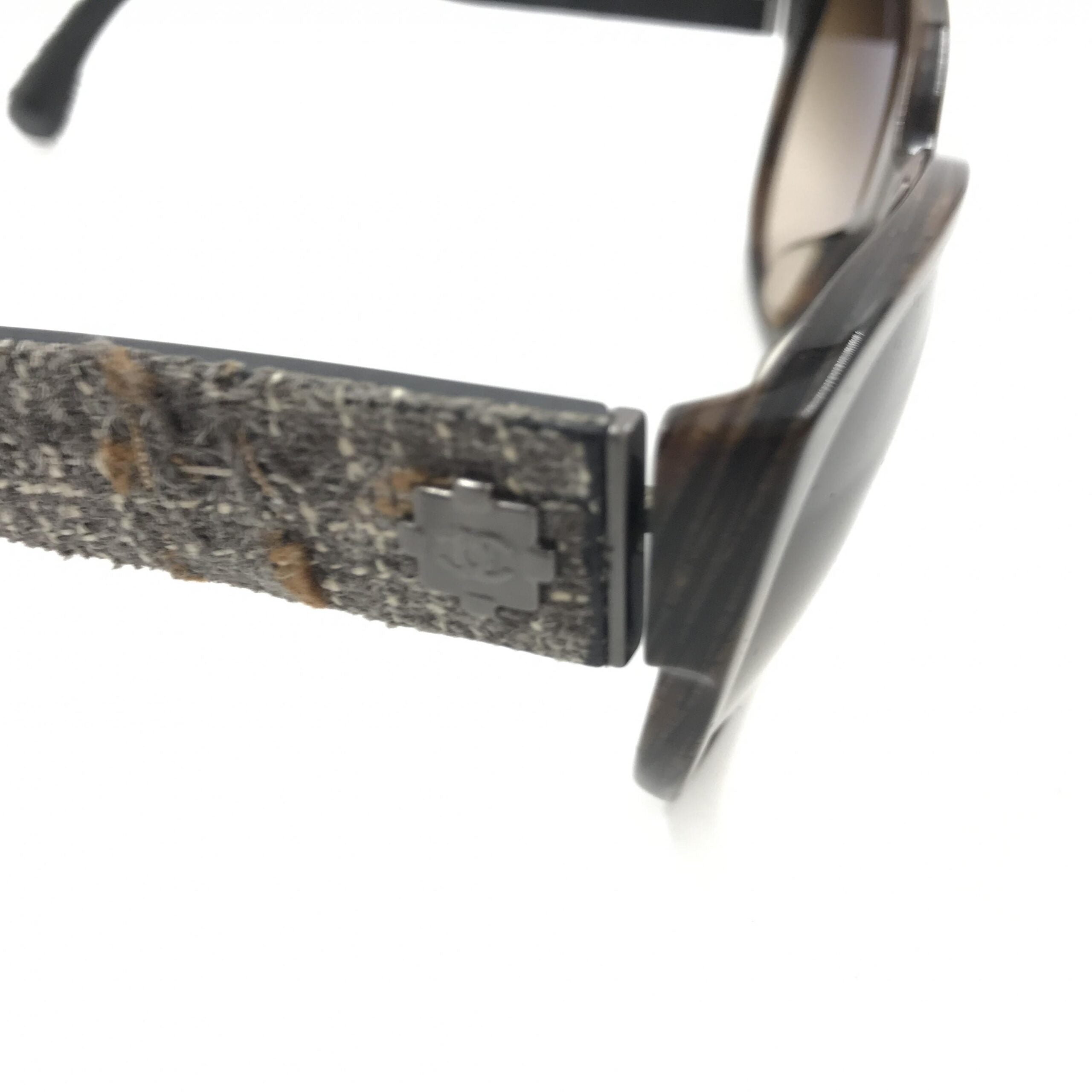 Lunettes de soleil Chanel avec monture marron et accents en tweed, style élégant et sophistiqué, vue de face.
