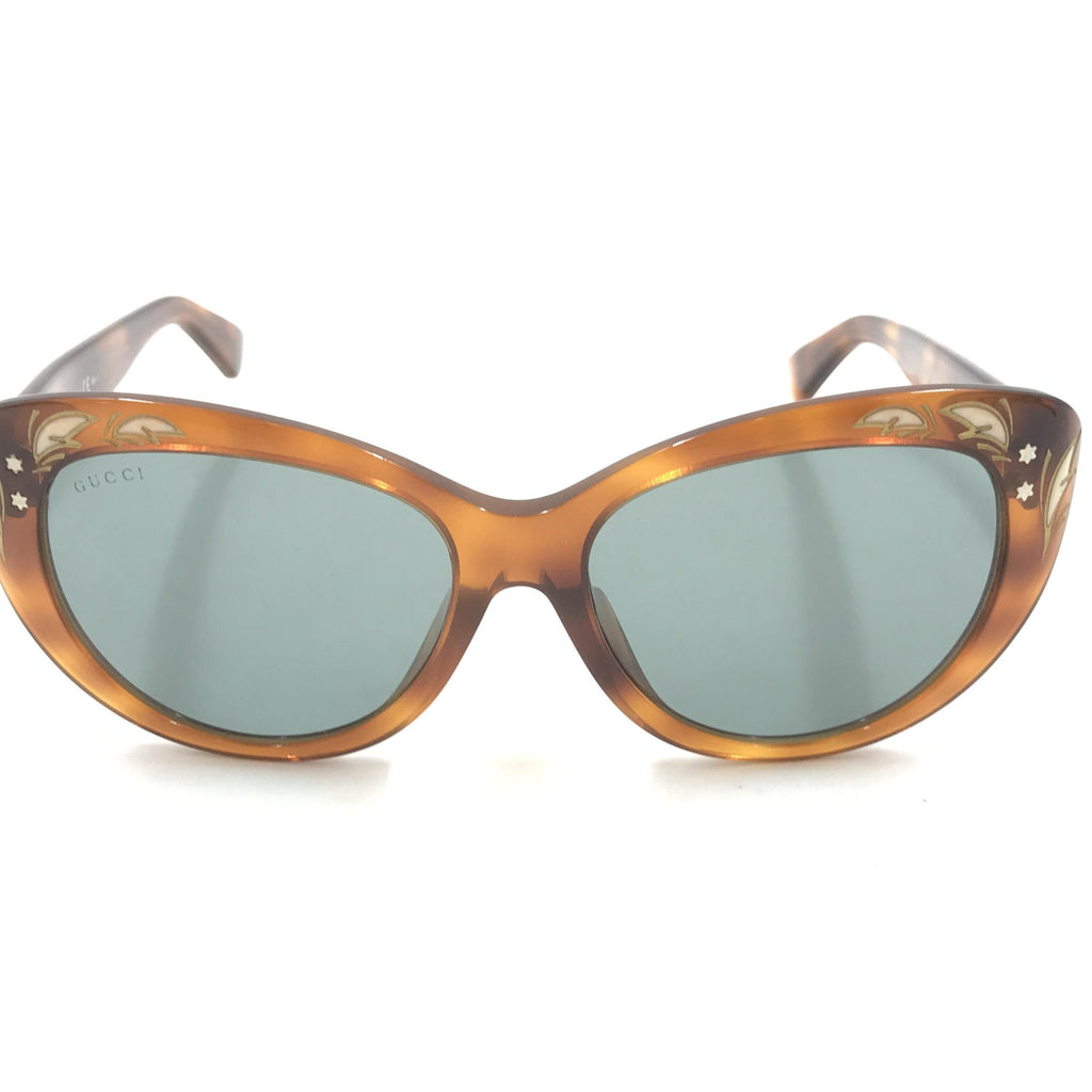 Lunettes de soleil Gucci style cat eye avec monture en tortoise, design élégant et tendance pour un look sophistiqué.