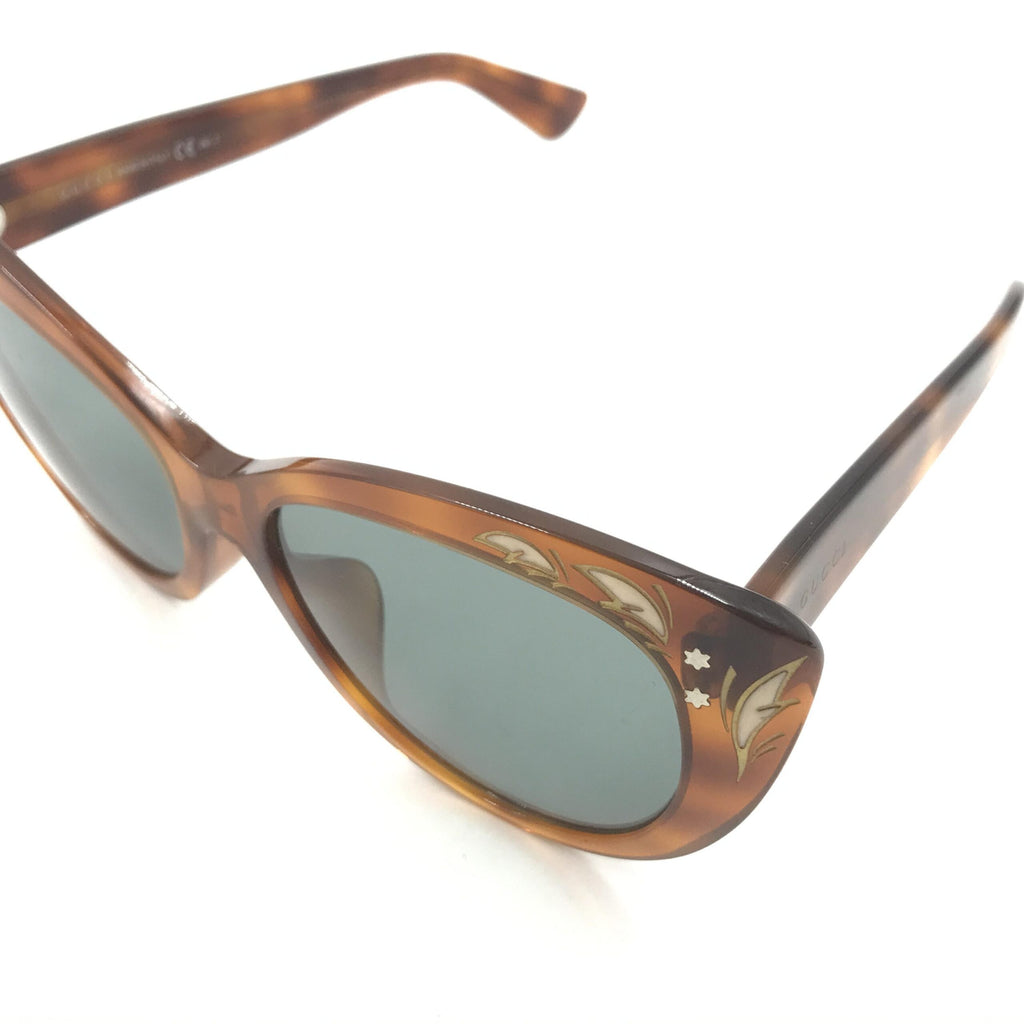 Lunettes de soleil Gucci avec monture œil de chat et motif écaille de tortue, élégantes et tendance.