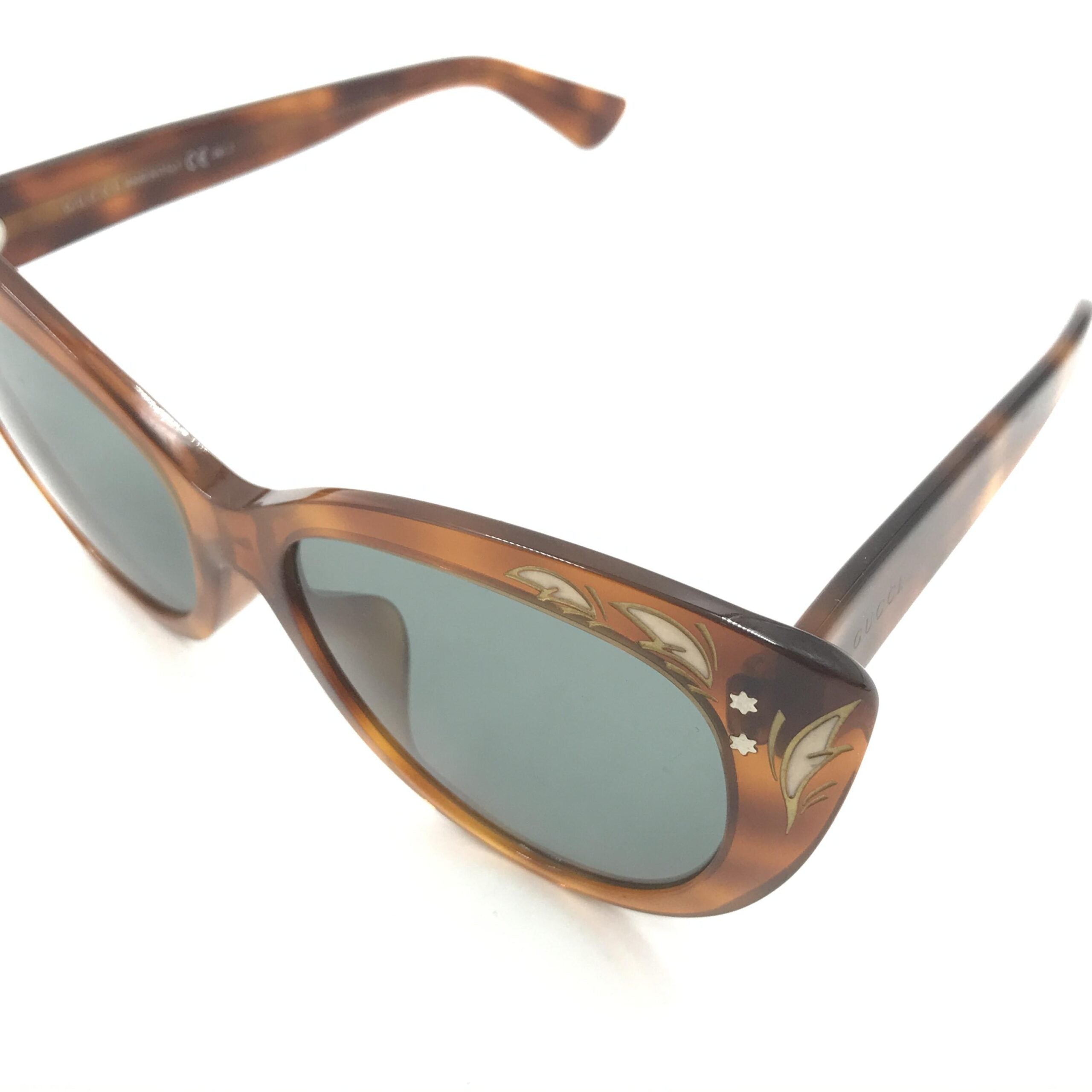 Lunettes de soleil Gucci avec monture œil de chat et motif écaille de tortue, élégantes et tendance.
