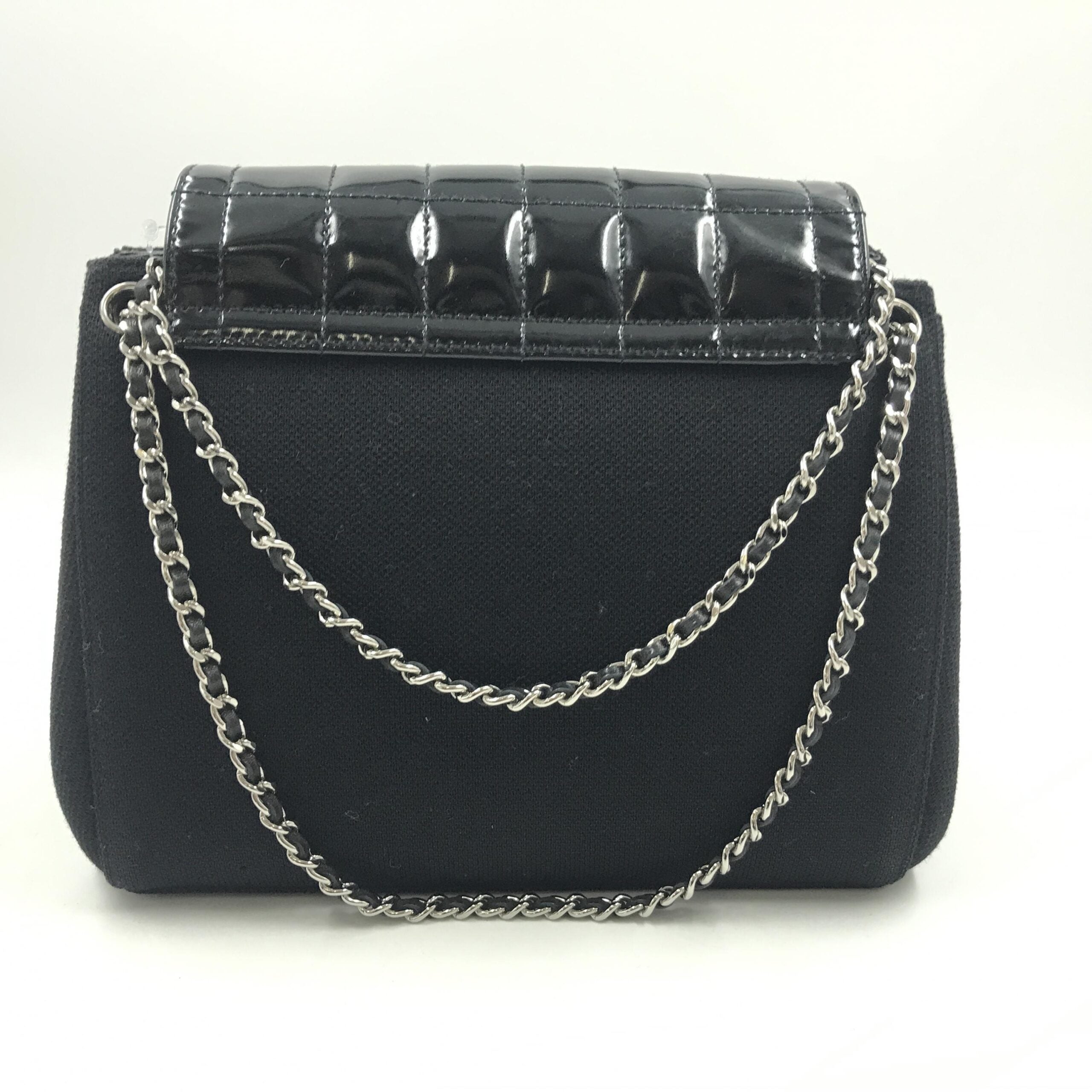 Sac Chanel en cuir verni chocolat avec bandoulière, élégant et sophistiqué, vue en gros plan sur la texture brillante.