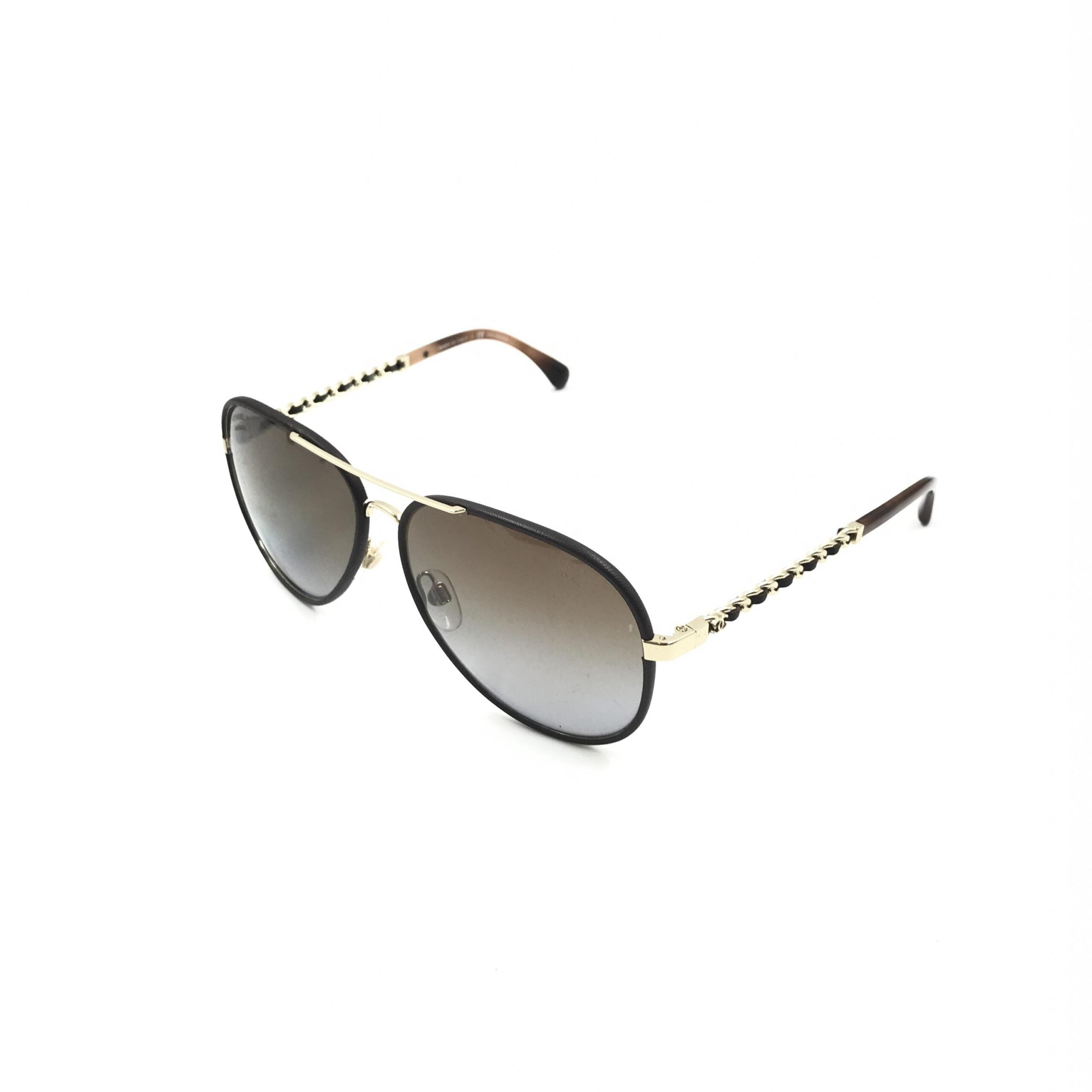 Lunettes de soleil aviateur Chanel avec monture dorée et noire, verres polarisés, style élégant et moderne.