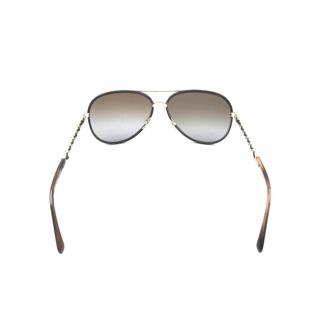 Lunettes de soleil aviator Chanel dorées et noires avec verres polarisés, style élégant et moderne.