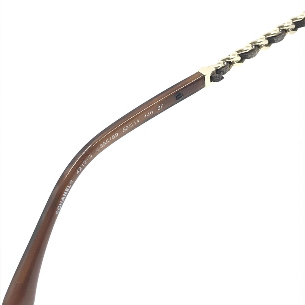 Lunettes de soleil aviator Chanel dorées et noires avec lentilles polarisantes, style élégant et sophistiqué.