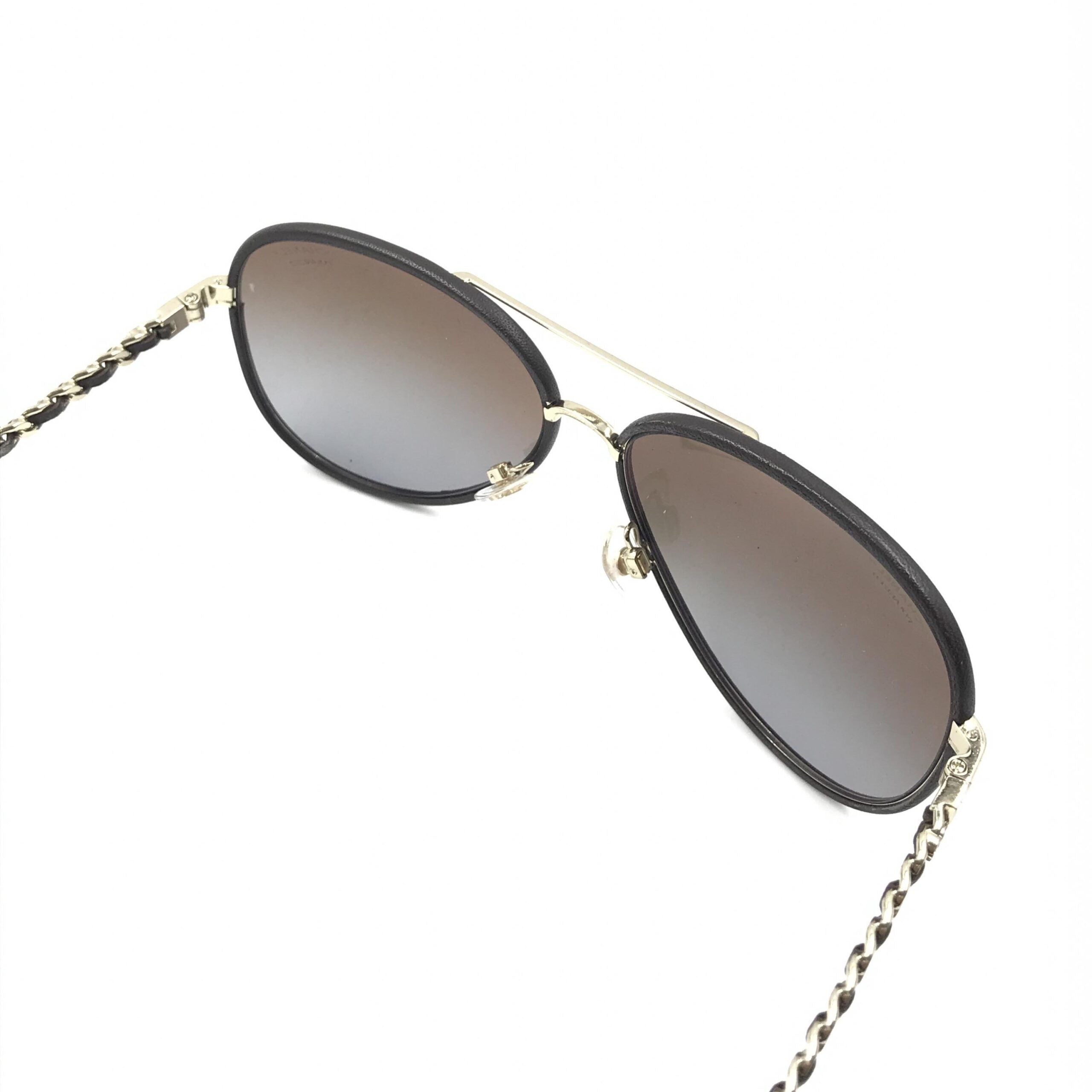 Lunettes de soleil aviateur Chanel dorées et noires avec verres polarisés, style élégant et tendance.