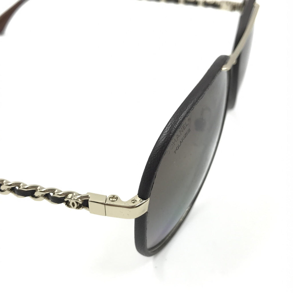 Lunettes de soleil aviator Chanel dorées et noires avec verres polarisés, style élégant et moderne.
