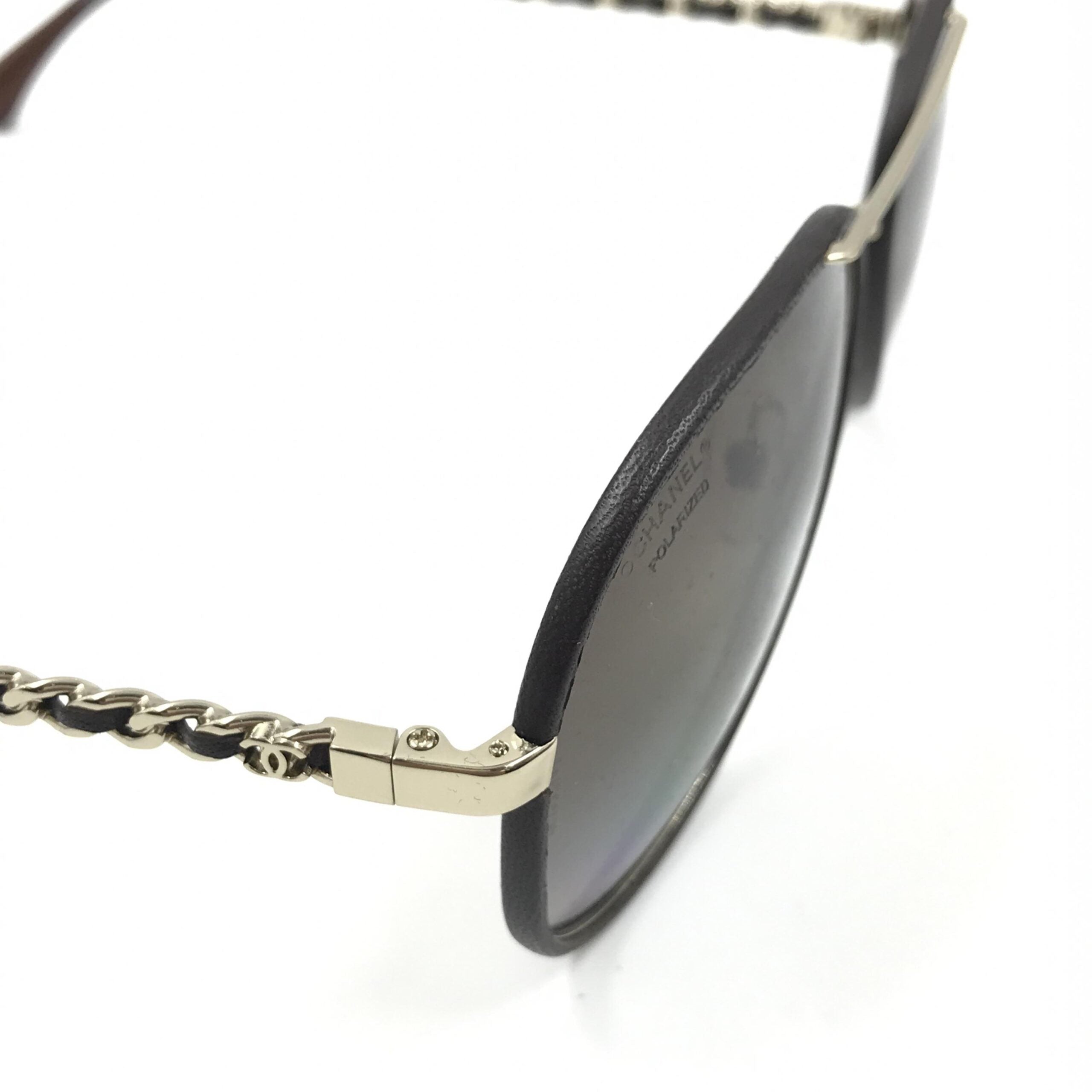 Lunettes de soleil aviator Chanel dorées et noires avec verres polarisés, style élégant et moderne.