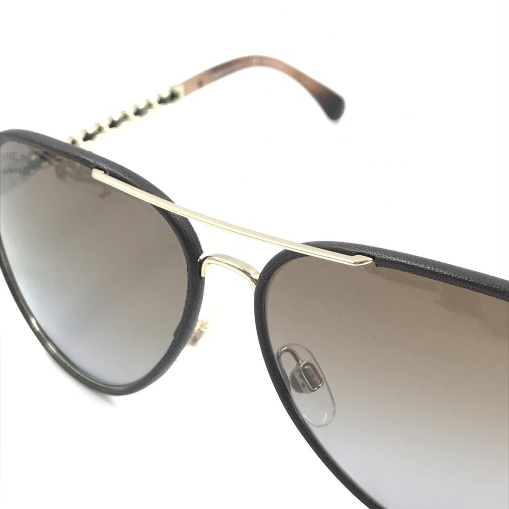 Lunettes de soleil aviateur Chanel en or et noir avec verres polarisés, style élégant et moderne.