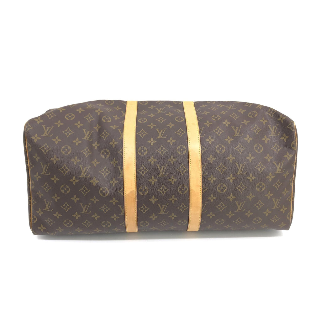 Sac à main Louis Vuitton Keepall 55 en monogramme, avec bandoulière et fermeture zippée visible sur l'image.