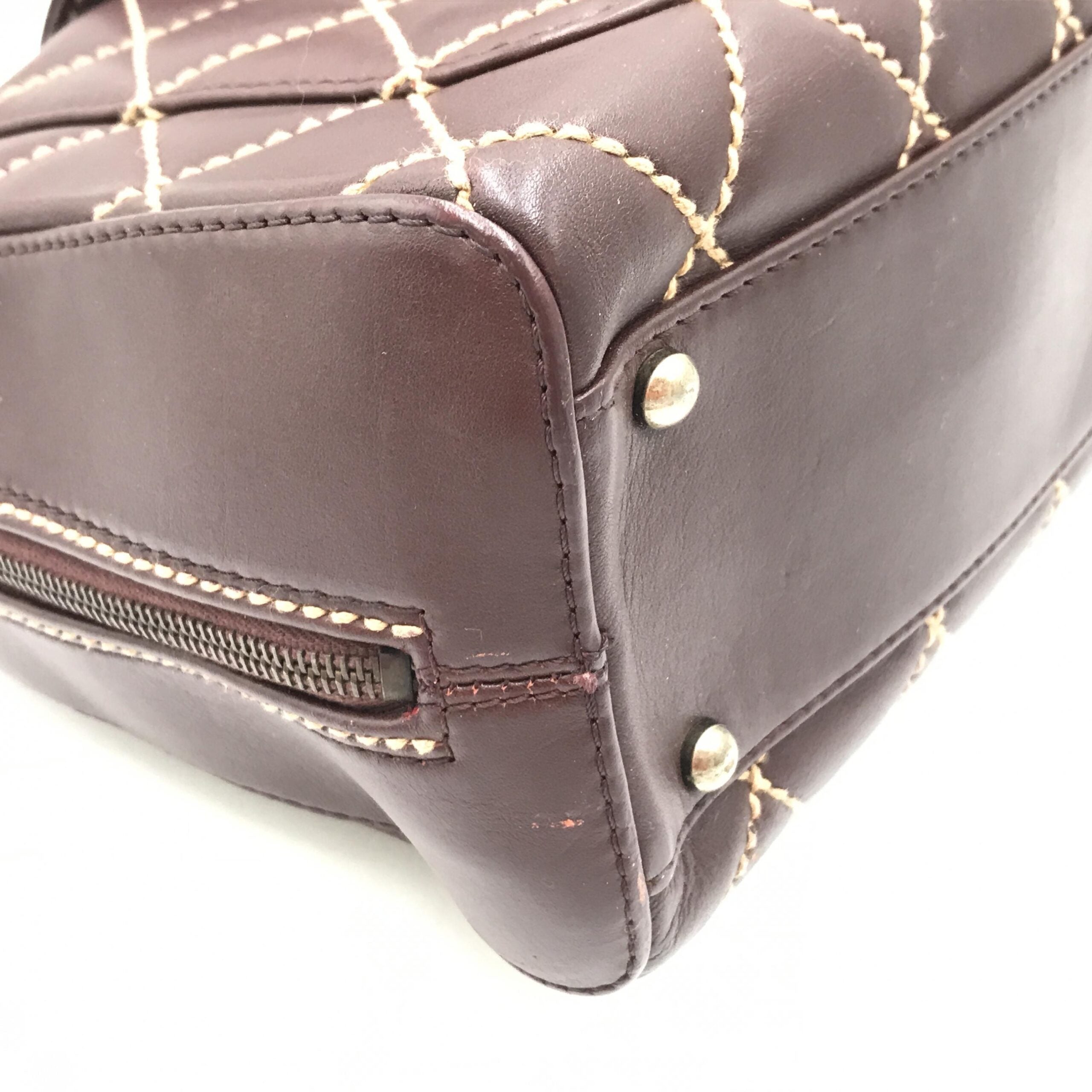 Sac à main Chanel Wild Stitch Mini Boston en cuir rouge, avec détails de couture distinctive et poignée en métal doré.