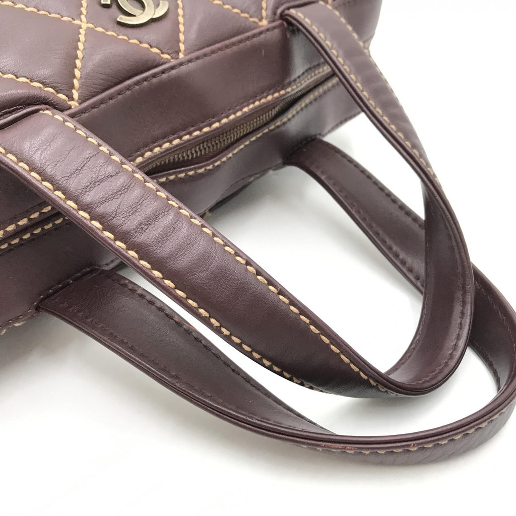 Sac à main Chanel Wild Stitch Mini Boston rouge, en cuir avec couture décorative, présenté dans une vue rapprochée.