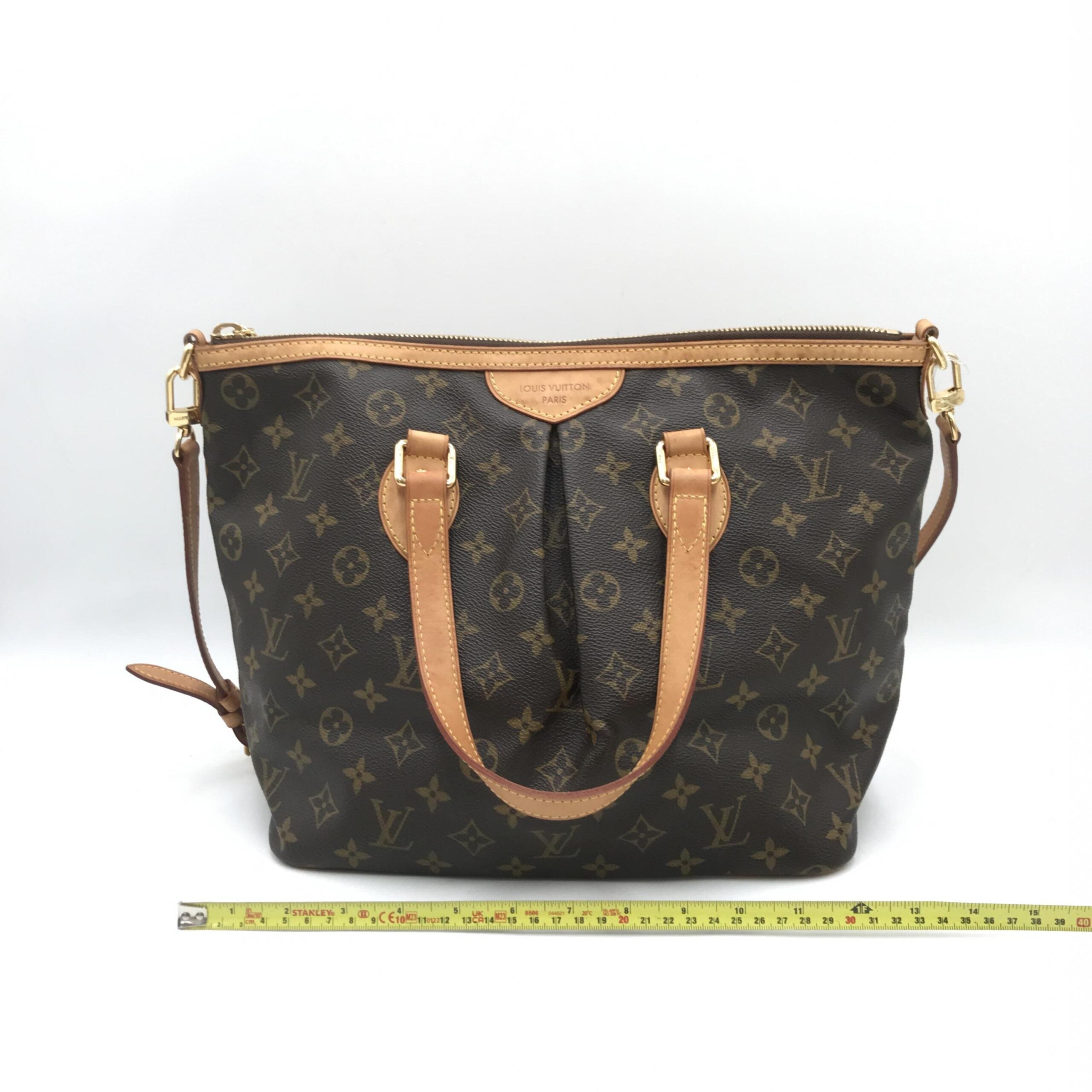 Sac Louis Vuitton Monogram Palermo PM avec poignée en cuir, fermé par une fermeture éclair, posé sur une surface neutre.