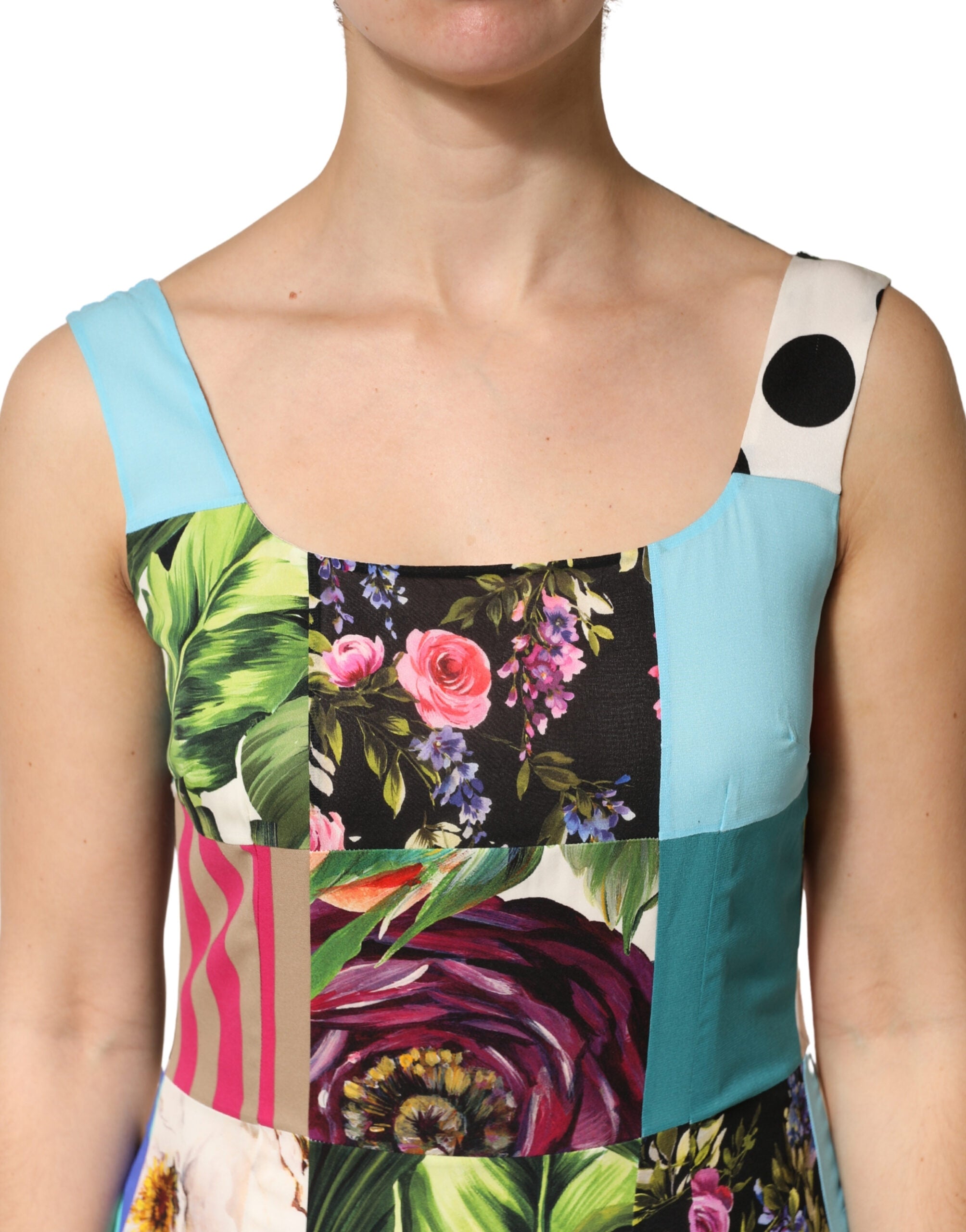 Robe sans manches en soie multicolore avec patchwork de Dolce & Gabbana, élégante et colorée, portée sur un fond neutre.