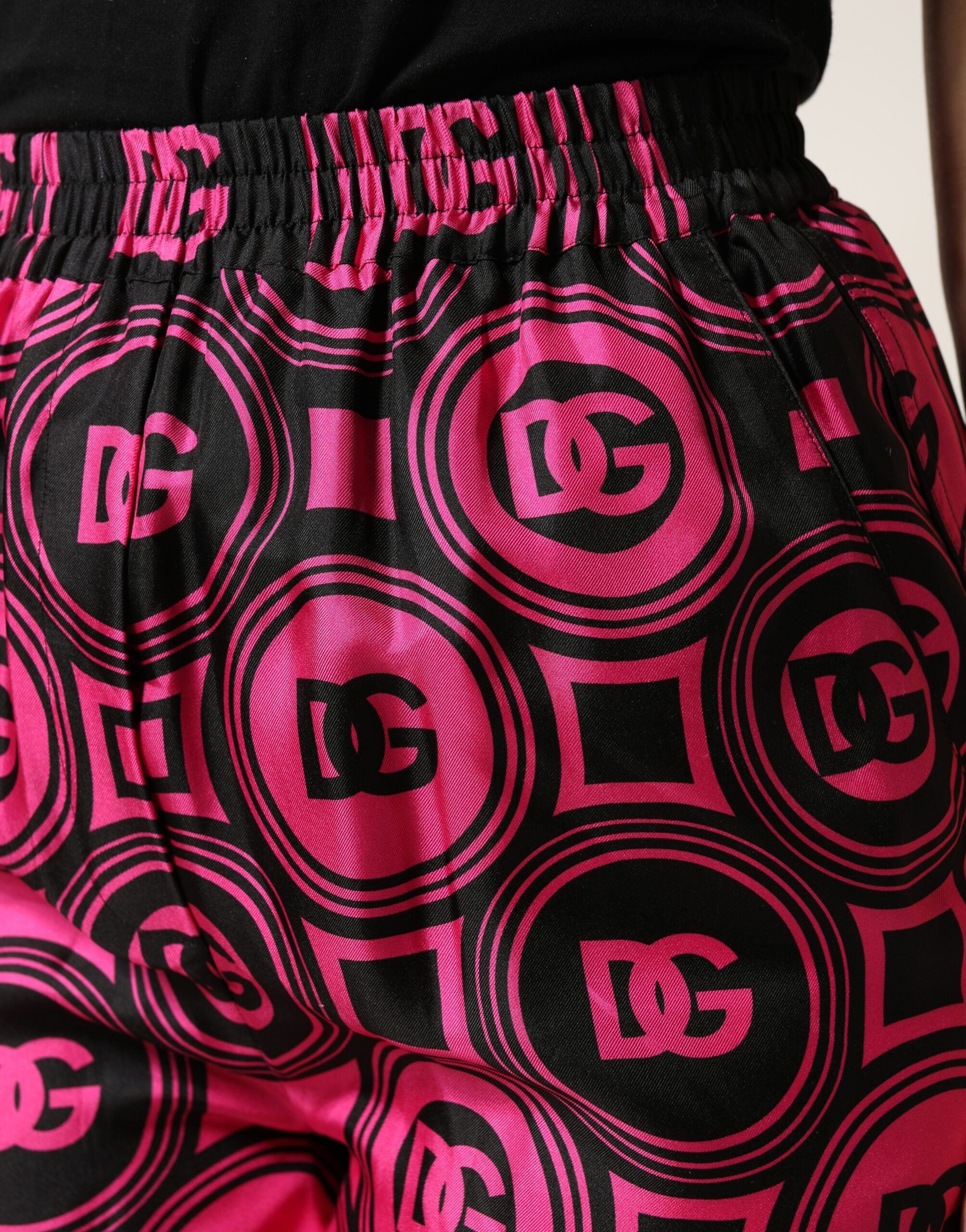 Shorts en soie noire et fuchsia Dolce & Gabbana avec logo, taille élastique, style décontracté et élégant.