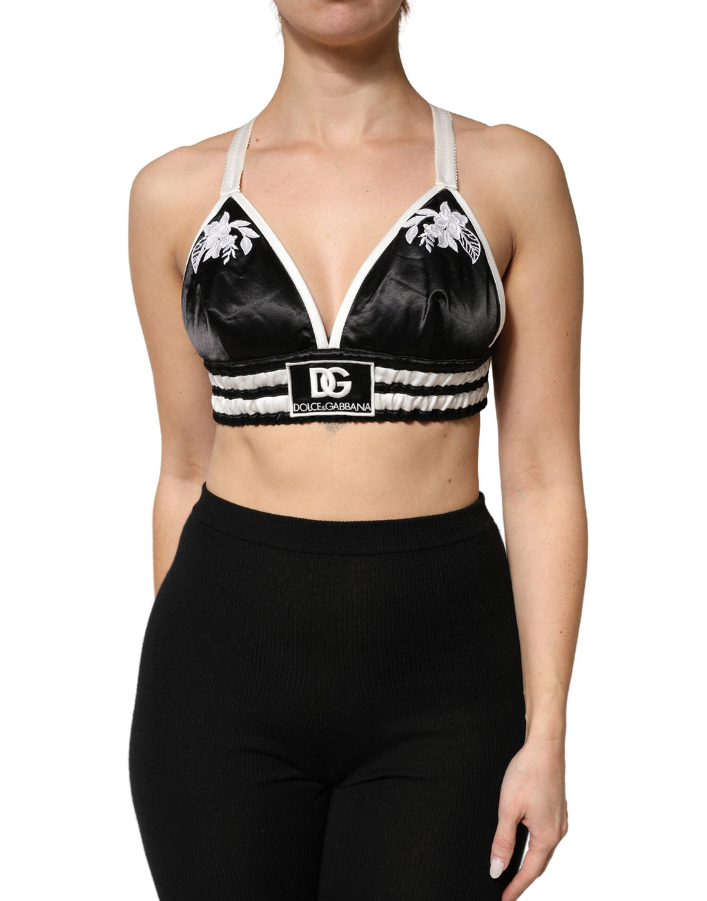 Brassière crop en soie satin noire à fleurs avec logo Dolce & Gabbana, ajustée et élégante, vue de face.