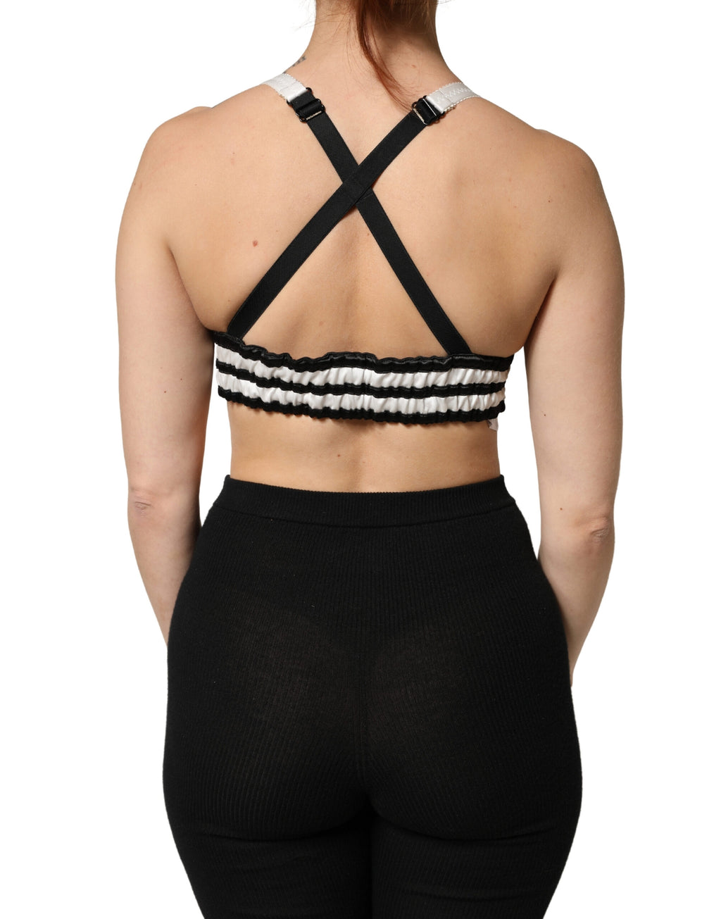 Top crop en satin de soie noir à fleurs avec logo Dolce & Gabbana, bralette élégant et féminin visible dans l'image.