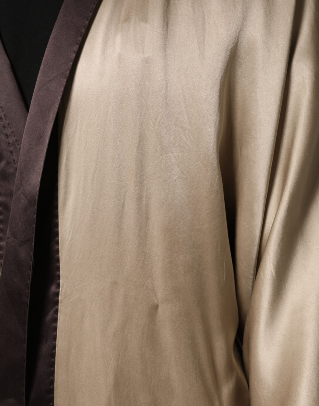 Longue robe manteau en soie satin beige de Dolce & Gabbana, élégante et sophistiquée, avec une coupe fluide et luxueuse.
