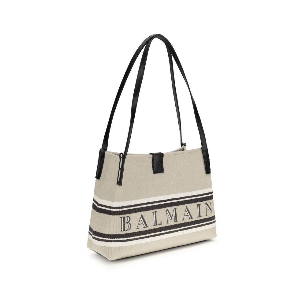 Sac bandoulière beige en coton de la marque Balmain, détail visible avec poignées et logo sur le devant.