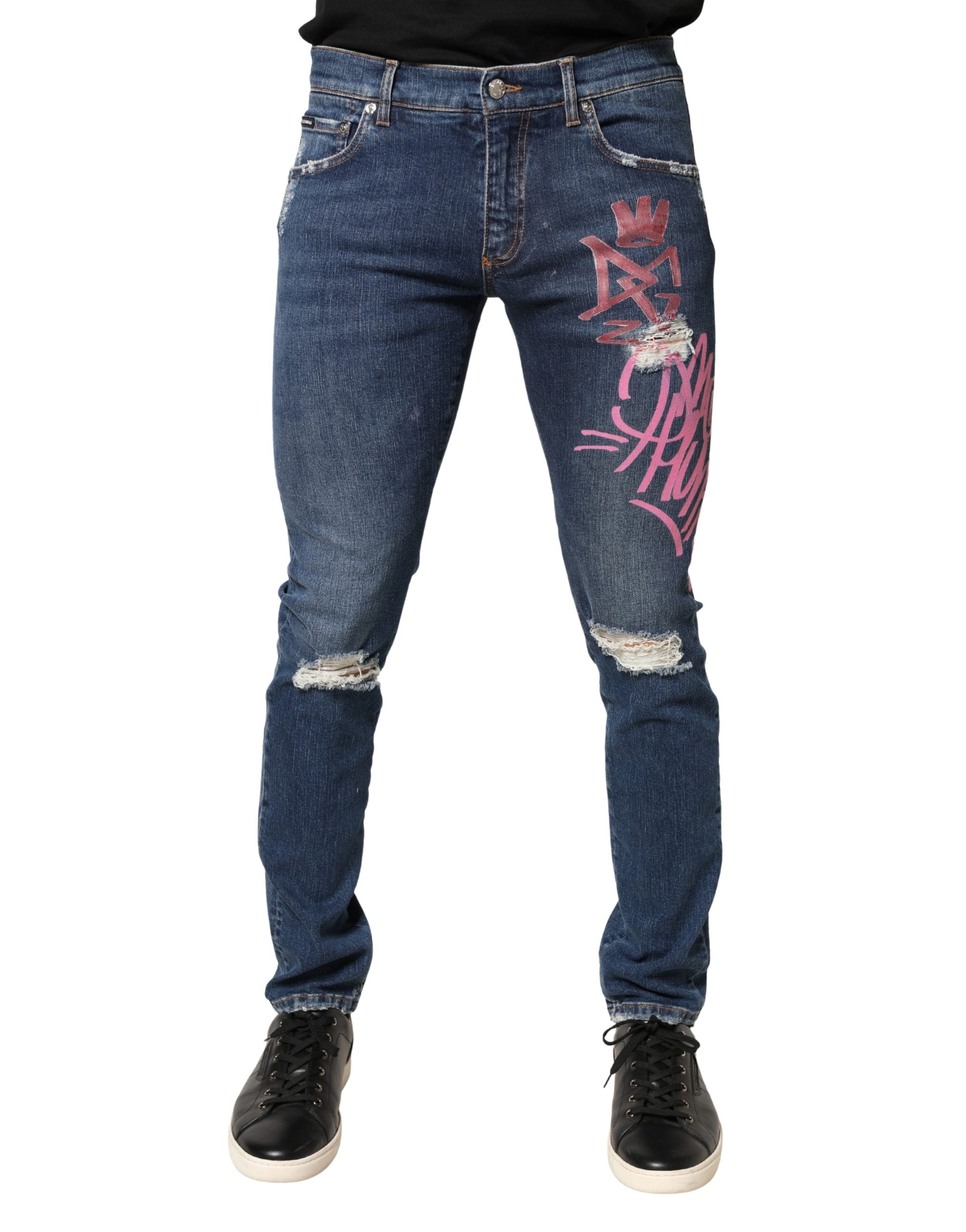 Jeans skinny Dolce & Gabbana à imprimé graffiti délavé et usé, en denim bleu avec détails distressed.
