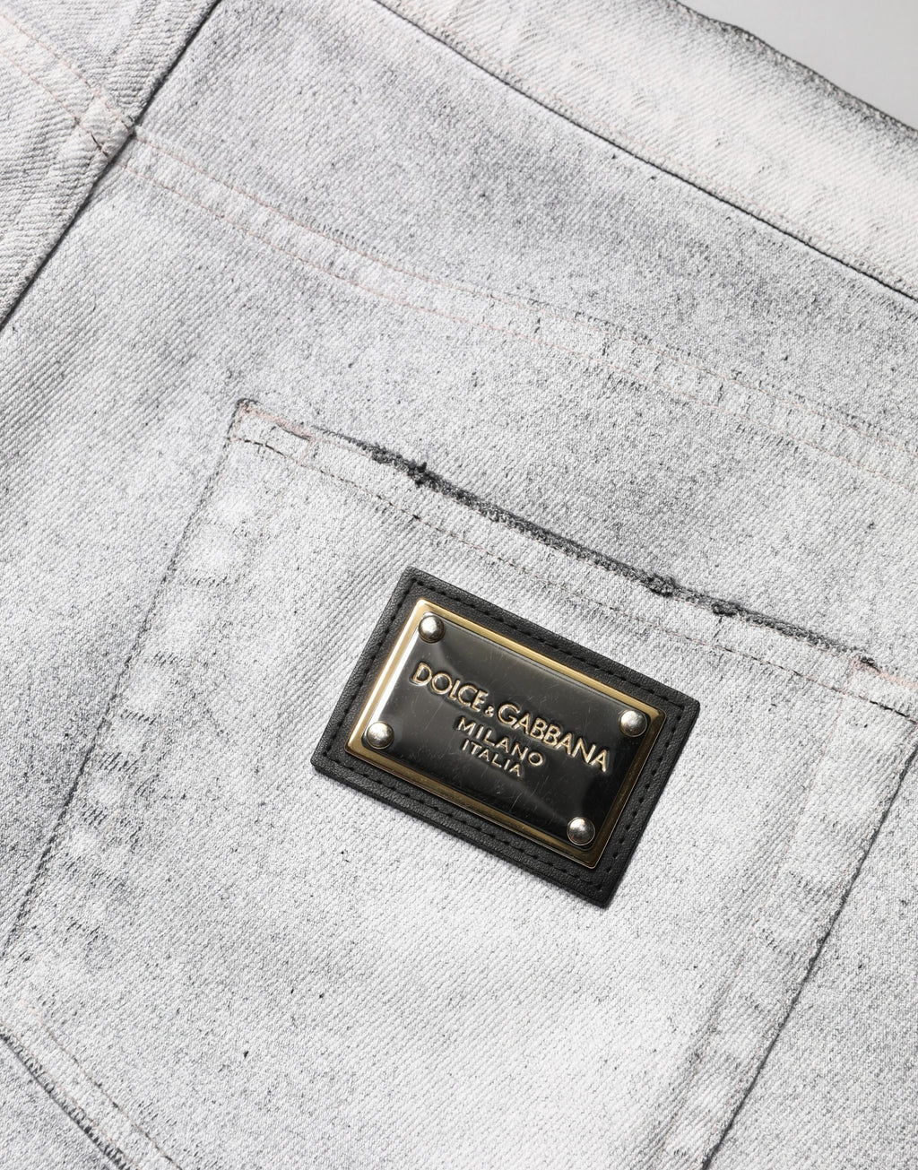 Jeans homme skinny gris clair Dolce & Gabbana en denim déchiré, coupe ajustée et détails usés visibles sur l'image.