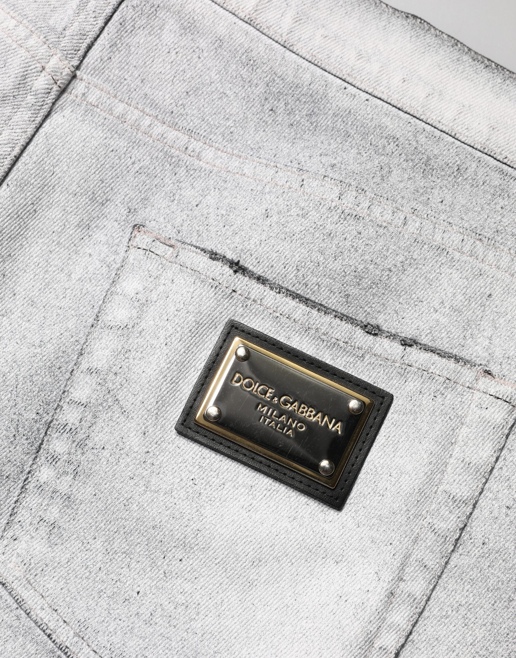 Jeans homme skinny gris clair Dolce & Gabbana en denim déchiré, coupe ajustée et détails usés visibles sur l'image.