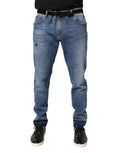 Jeans skinny en denim de coton bleu déchiré de Dolce & Gabbana, style tattered et tendance, visible sur l'image.