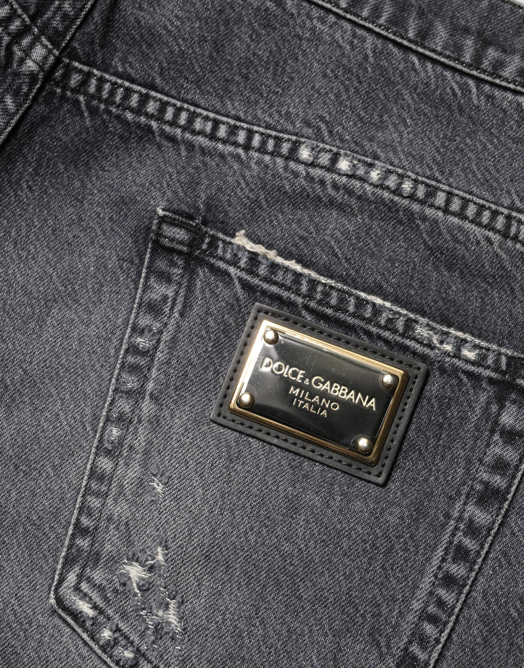 Jean en denim gris foncé déchiré, style décontracté et ample, de la marque Dolce & Gabbana, visible avec détails usés et coupe large.